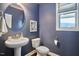 Stylish powder room with a pedestal sink, round mirror, and window with blinds at 1808 Capstone Dr, Durham, NC 27713