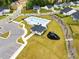 Aerial view of a neighborhood pool with clubhouse and playground amidst homes and green lawns at 1891 Ballard Rd # 192, Fuquay Varina, NC 27526