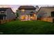 Back exterior of home with well-manicured lawn, and a fenced in yard, at dusk at 1908 Woodsdale Dr, Durham, NC 27703