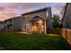 Back exterior of home with well-manicured lawn, and a fenced in yard, at dusk at 1908 Woodsdale Dr, Durham, NC 27703