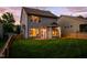 Inviting backyard at twilight, highlighting the warm glow from the windows and the lush green lawn at 1908 Woodsdale Dr, Durham, NC 27703