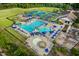 Aerial view of a community pool area with lounge chairs, a playground, and well-maintained landscaping at 1908 Woodsdale Dr, Durham, NC 27703