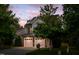 Charming home exterior with a two-car garage, stone accents, and manicured lawn at dusk at 1908 Woodsdale Dr, Durham, NC 27703