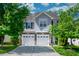 Inviting home exterior with a two-car garage, gray siding, and a well-manicured front lawn at 1908 Woodsdale Dr, Durham, NC 27703