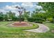 Landscaped common area with a decorative birdhouse tree feature along a walking path at 1908 Woodsdale Dr, Durham, NC 27703