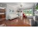 Bright living room with hardwood floors, white sofa, and large windows overlooking the backyard at 1908 Woodsdale Dr, Durham, NC 27703