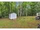 Backyard featuring a storage shed with an outdoor space surrounded by mature trees at 196 Marlin Ln, Smithfield, NC 27577