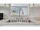 Close up of stainless steel kitchen sink, updated faucet, and subway tile backsplash at 196 Marlin Ln, Smithfield, NC 27577
