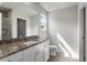Bathroom featuring granite countertops, white cabinetry, and a framed vanity mirror at 203 Benton Dr, Oxford, NC 27565