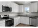 Bright kitchen with stainless steel appliances, light granite countertops, and sleek white cabinetry at 203 Benton Dr, Oxford, NC 27565