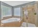 Bright bathroom featuring a soaking tub, glass block windows, and a glass-enclosed shower at 205 Forbes Rd, Wake Forest, NC 27587