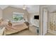 Bright bedroom with large window, TV, and an adjacent bathroom with shower at 205 Forbes Rd, Wake Forest, NC 27587