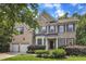 Charming two-story brick home featuring a well-manicured lawn, attached two-car garage, and beautifully landscaped front yard at 205 Forbes Rd, Wake Forest, NC 27587