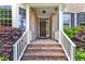 Inviting front porch featuring brick steps, white railing, and a decorative wreath on the front door at 205 Forbes Rd, Wake Forest, NC 27587