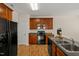 Kitchen featuring black appliances, wood cabinets, and laminate flooring at 207 Bell Tower Way, Morrisville, NC 27560