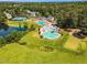 Aerial view of community swimming pool, lazy river, playground, tennis courts, and beautiful pond with mature trees at 208 Gillean Ln, Holly Springs, NC 27540