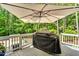 A white deck featuring a black grill covered by a light color umbrella at 208 Gillean Ln, Holly Springs, NC 27540