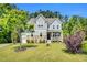 Charming two-story home featuring a well-manicured lawn, stone accents, and a welcoming front porch at 208 Gillean Ln, Holly Springs, NC 27540
