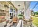 Inviting front porch with stone accents, a comfortable bench, and stylish outdoor lighting at 208 Gillean Ln, Holly Springs, NC 27540