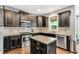 Stylish kitchen featuring stainless steel appliances, granite countertops, and a kitchen island at 208 Gillean Ln, Holly Springs, NC 27540
