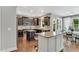 Modern kitchen with dark cabinetry, granite countertops, island seating, and a breakfast nook at 208 Gillean Ln, Holly Springs, NC 27540