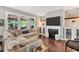 Cozy living room with fireplace, large windows, hardwood floors and comfortable sectional sofa at 208 Gillean Ln, Holly Springs, NC 27540