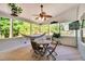 Relaxing screened porch featuring a ceiling fan, hammock, and green nature views at 208 Gillean Ln, Holly Springs, NC 27540