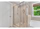 Shower with glass door and neutral tile in a bright bathroom at 208 Gillean Ln, Holly Springs, NC 27540