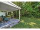 Covered patio with seating area overlooking a green, tree-filled backyard at 215 N 4Th St, Smithfield, NC 27577