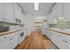 Galley kitchen with white cabinetry, laminate countertops, and modern appliances at 2240 Delaney Dr, Burlington, NC 27215