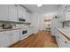 Well-lit kitchen featuring white appliances and cabinets, with a dining area in the background at 2240 Delaney Dr, Burlington, NC 27215