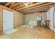 An unfinished room featuring exposed wood and insulation with a single-entry door and a window at 2240 Delaney Dr, Burlington, NC 27215
