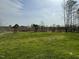 A spacious grassy backyard with tree line and a blue sky overhead at 235 Starry Sky Dr, Benson, NC 27504