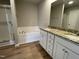 Bathroom featuring a double sink vanity with granite counters, soaking tub and glass-enclosed shower at 235 Starry Sky Dr, Benson, NC 27504