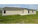 Rear exterior view of the home showing tan siding and a small patio at 235 Starry Sky Dr, Benson, NC 27504