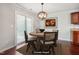Charming dining area featuring hardwood floors, a modern chandelier, and a sliding glass door at 2523 Ferdinand Dr, Knightdale, NC 27545