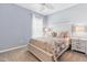 Cozy bedroom with a floral-themed comforter, light blue walls, and ample natural light at 2531 Impulsion Dr, New Hill, NC 27562