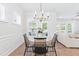 Cozy dining area with chandelier lighting, wood floors, and natural light from large windows at 2531 Impulsion Dr, New Hill, NC 27562