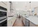 Bright kitchen featuring white cabinets, stainless steel appliances, and an open layout to the dining area at 2531 Impulsion Dr, New Hill, NC 27562