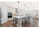 Modern kitchen features a large center island with seating, pendant lights, and stainless steel appliances at 2531 Impulsion Dr, New Hill, NC 27562