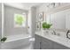 Bathroom featuring tub with shower, gray vanity with white countertop, and picture frame decor at 2540 Atlantic St, Durham, NC 27707