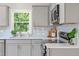 Kitchen boasts grey cabinets, stainless steel appliances, quartz countertops, and a subway tile backsplash at 2540 Atlantic St, Durham, NC 27707