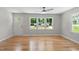 Sunlit living room featuring hardwood floors and three large windows with views of the outdoors at 2540 Atlantic St, Durham, NC 27707