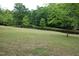 Expansive backyard with lush green lawn and tranquil pond surrounded by mature trees at 2600 Snow Hill Rd, Durham, NC 27712