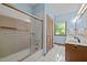 Light blue bathroom with tile floors, glass shower door, double sinks, and window views at 2600 Snow Hill Rd, Durham, NC 27712