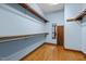 Walk-in closet with wooden shelving and door-length mirror, providing ample storage space at 2600 Snow Hill Rd, Durham, NC 27712
