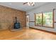 Inviting living room featuring a striking brick accent wall with a wood-burning stove and natural light at 2600 Snow Hill Rd, Durham, NC 27712