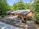 Rear exterior features multiple garden beds, screened in porch, deck, and beautiful brickwork at 2600 Snow Hill Rd, Durham, NC 27712