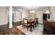 Bright dining area with dark wood table, elegant chandelier, and hardwood floors at 2735 Clifton Ave, Creedmoor, NC 27522