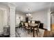 Formal dining room with elegant chandelier, dark wood furniture, and decorative columns at 2735 Clifton Ave, Creedmoor, NC 27522